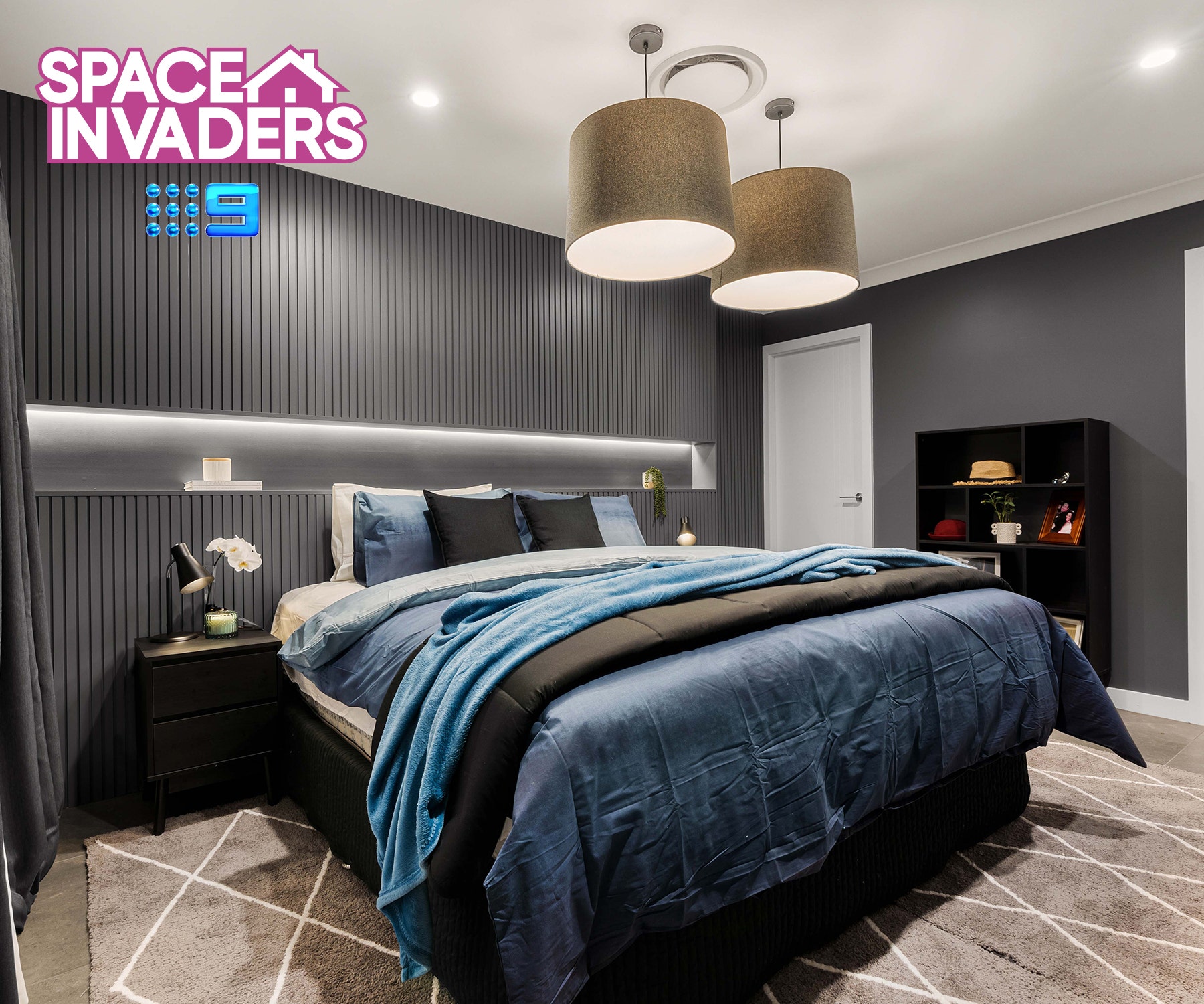 A renovated master room featured wall, luxury grey tiles, shades of blue bedding and ceiling lamps