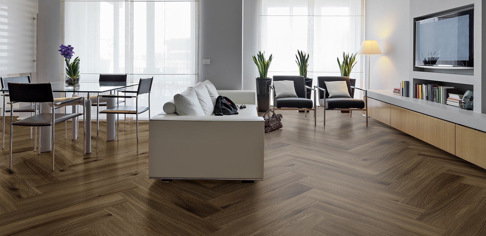 Living Room with Charm Walnut Herringbone Hybrid Textured Flooring Modern open-plan living and dining area featuring Charm Walnut Hybrid Textured flooring laid in a distinctive herringbone pattern, with contemporary furniture.