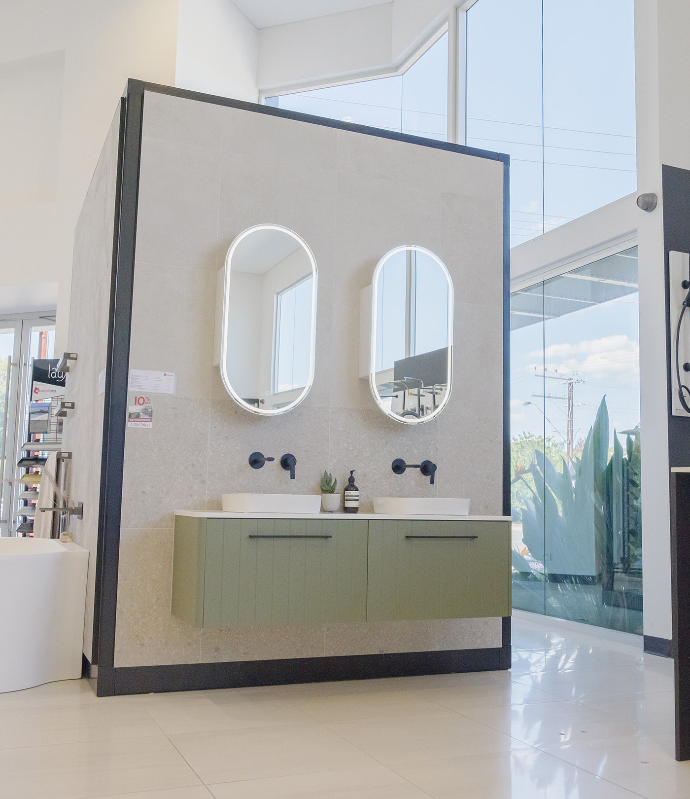 Complete Bathroom Package display with stone look tiles, olive green vanity, double white rounded basins, black tapware and two parallel rounded mirrors