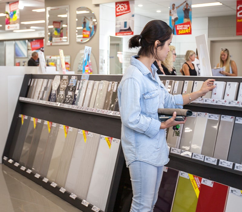Beaumont Tiles store inside, tiles on display an a customer checking the tiles