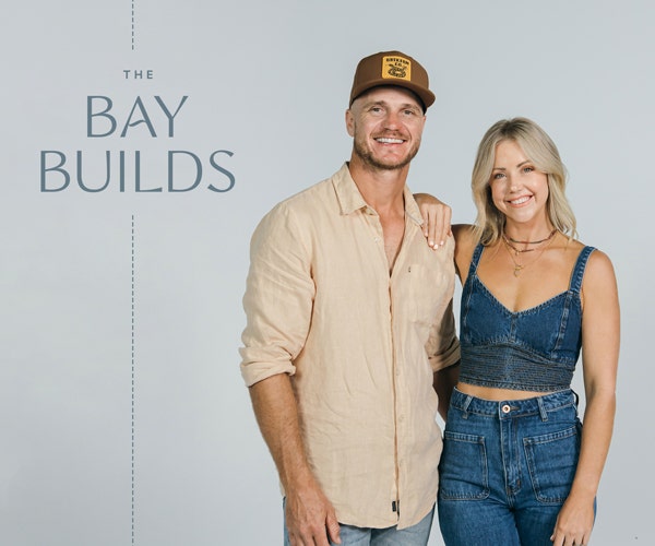 Kyal & Kara standing in a blue background and smiling one next to the other promoting their Bay Builds Web series