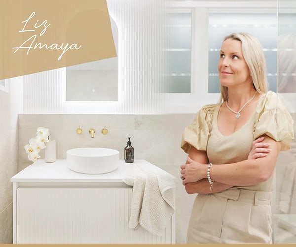 Liz Amaya radiating happiness, arms crossed, in front of the screen shower of her Beaumont Tiles-inspired bathroom