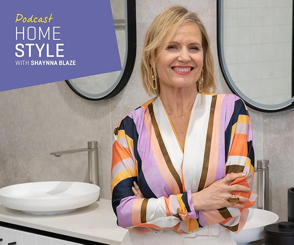 Shaynna Blaze, with a warm smile and arms crossed, promoting her home and style podcast in a stylish bathroom