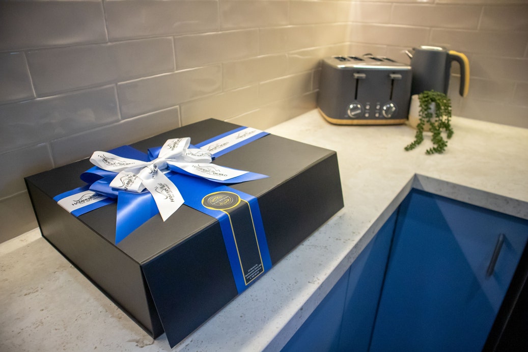 Close up to modern kitchen, Beaumont Tiles splashback tiles, blue cabinets, toaster and kettle